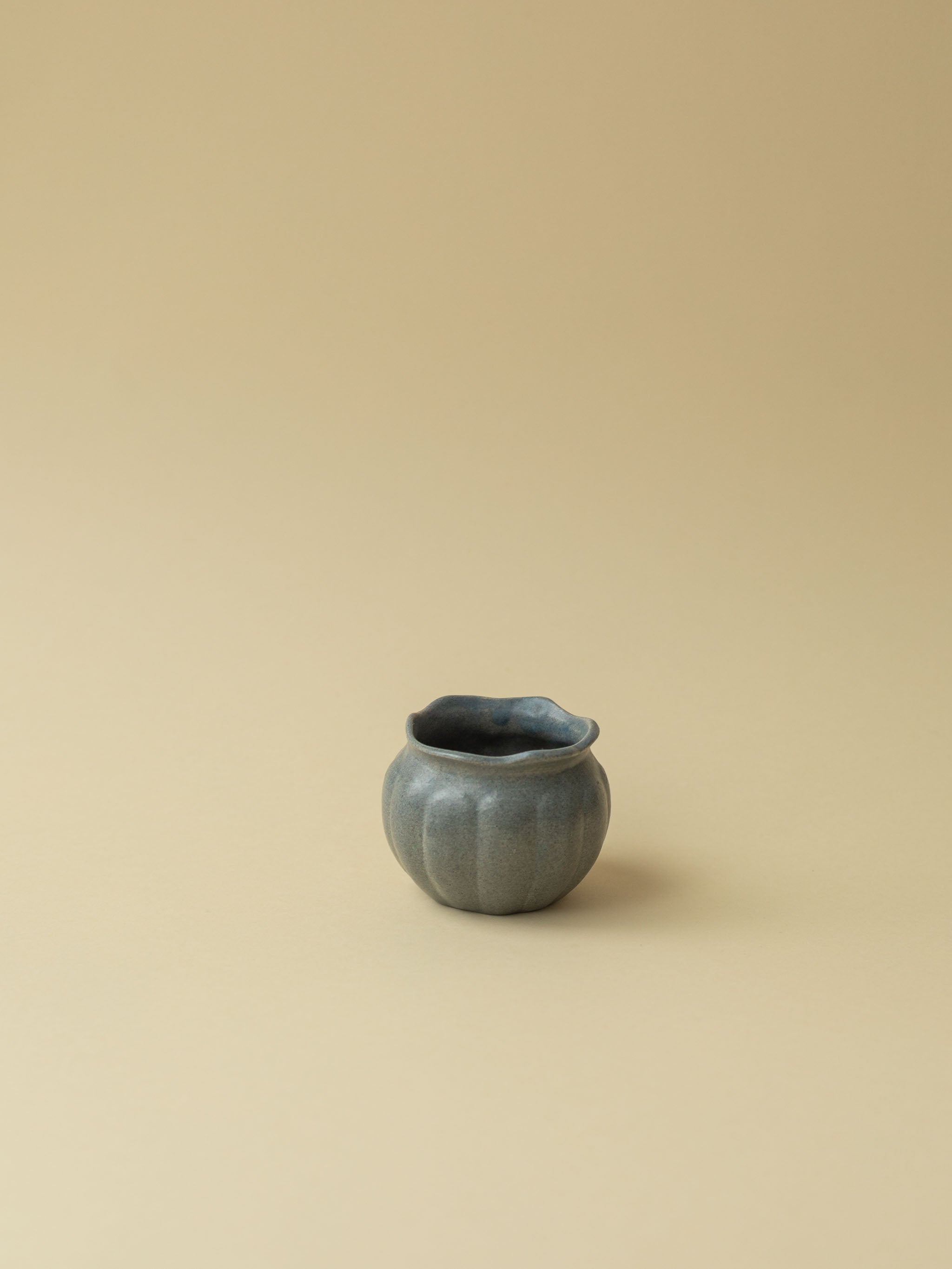 A small grey Kupittaan Savi vintage ceramic vase or pot. A view from the side. Scandinavian design from Finland.