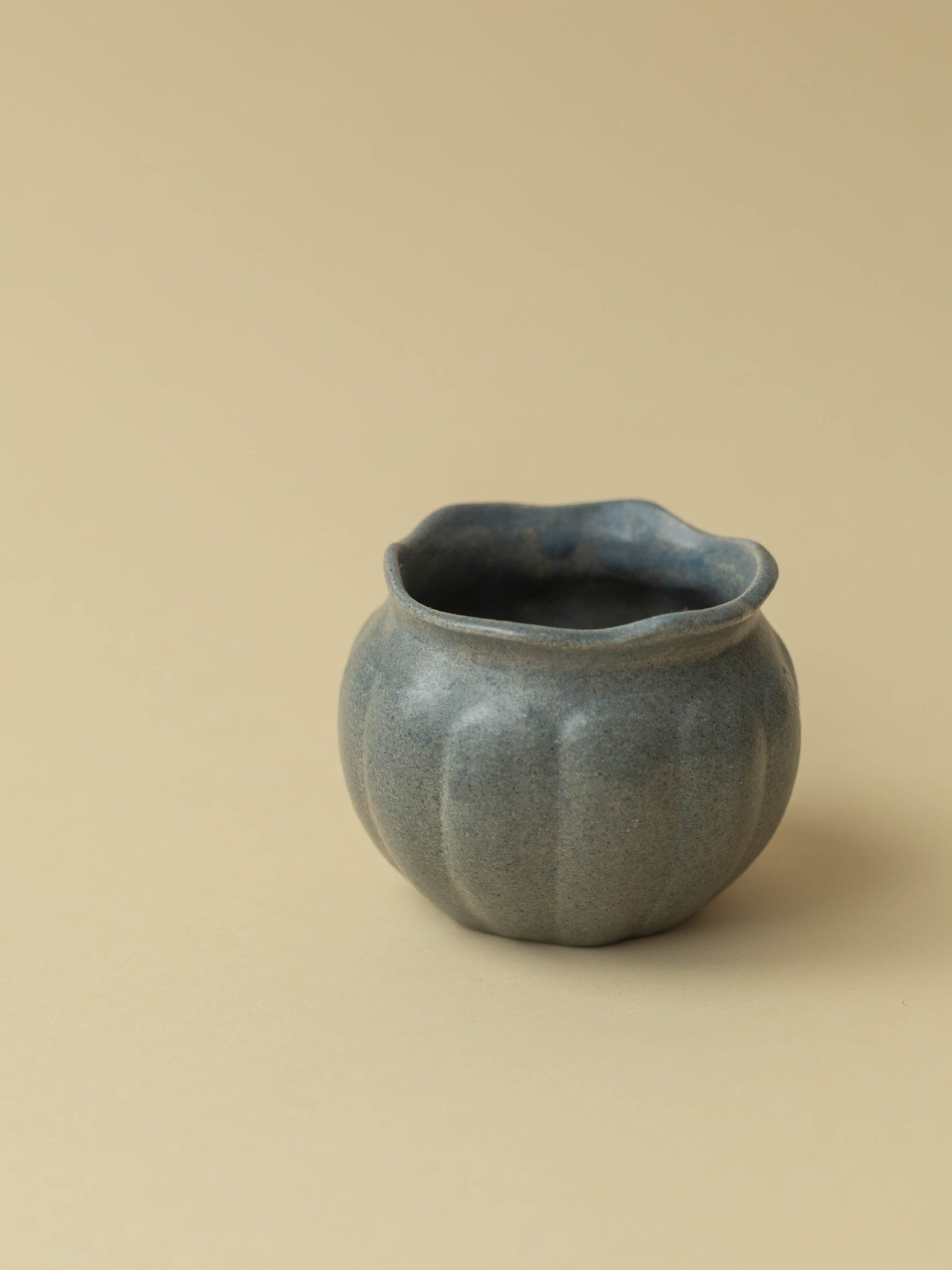 A small grey Kupittaan Savi vintage ceramic vase or pot. A side view. Scandinavian design from Finland.