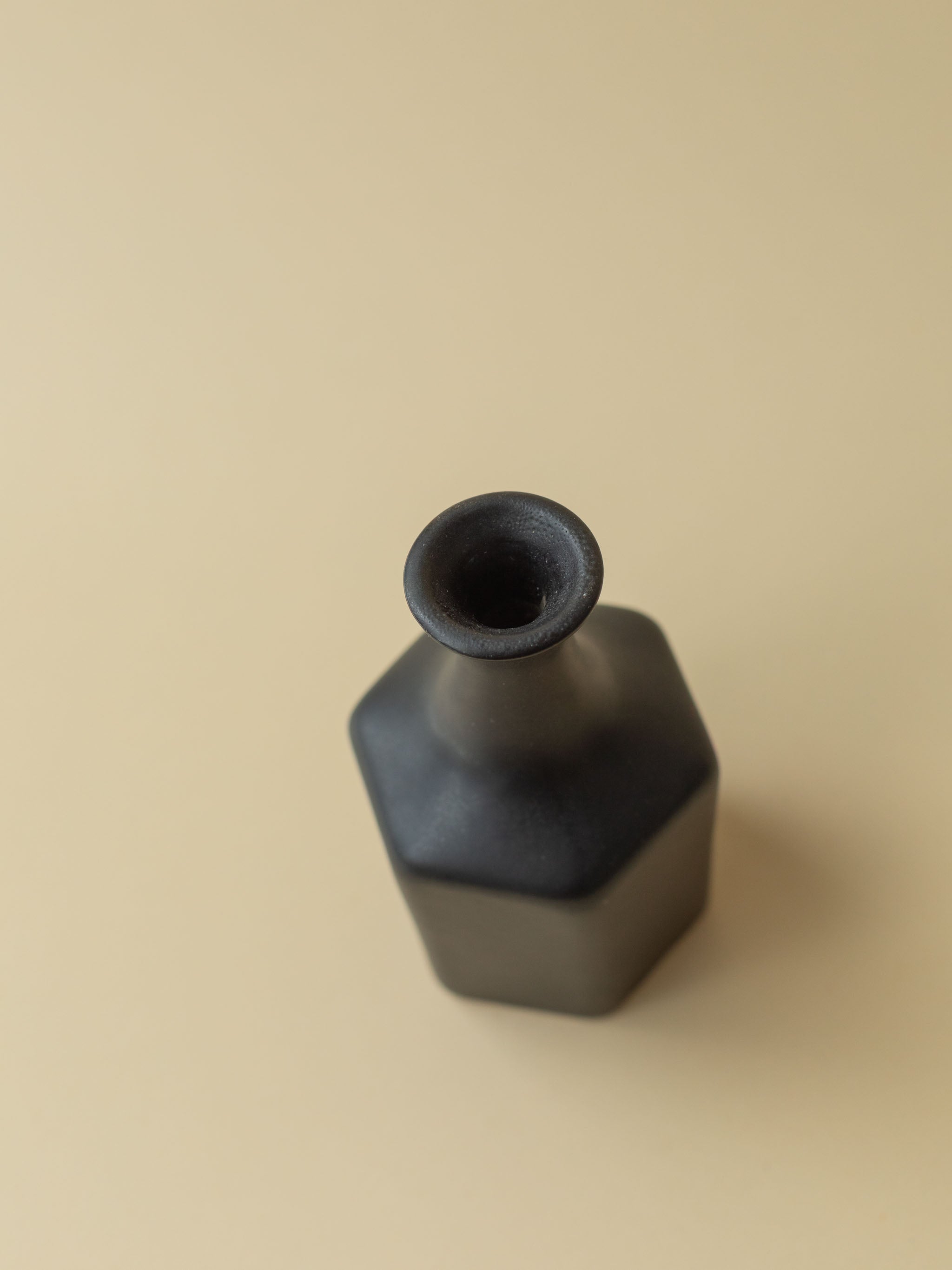 A black Kupittaan Savi vintage ceramic vase in bottle shape. Top view. Scandinavian design from Finland.