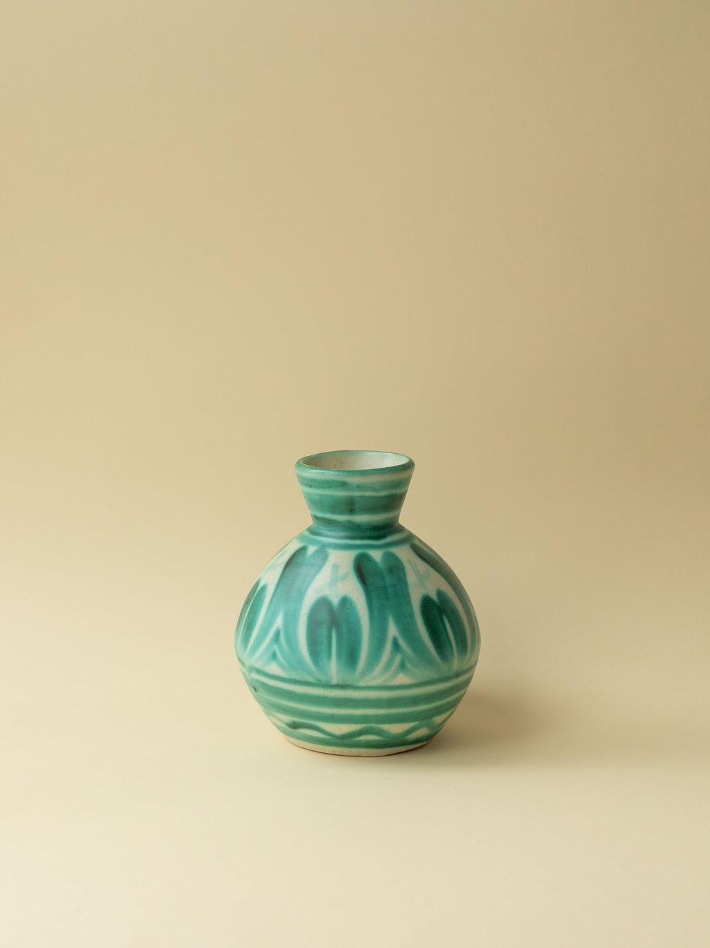 A green hand painted ceramic vintage vase by Kupittaan Savi. Scandinavian vintage vase from Finland. A view from the side.