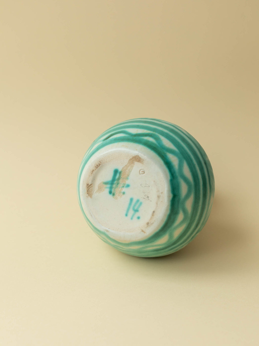 A green hand painted ceramic vintage vase by Kupittaan Savi. Scandinavian vintage vase from Finland. A view of the bottom showing the signature Helmi Suova and numbering.