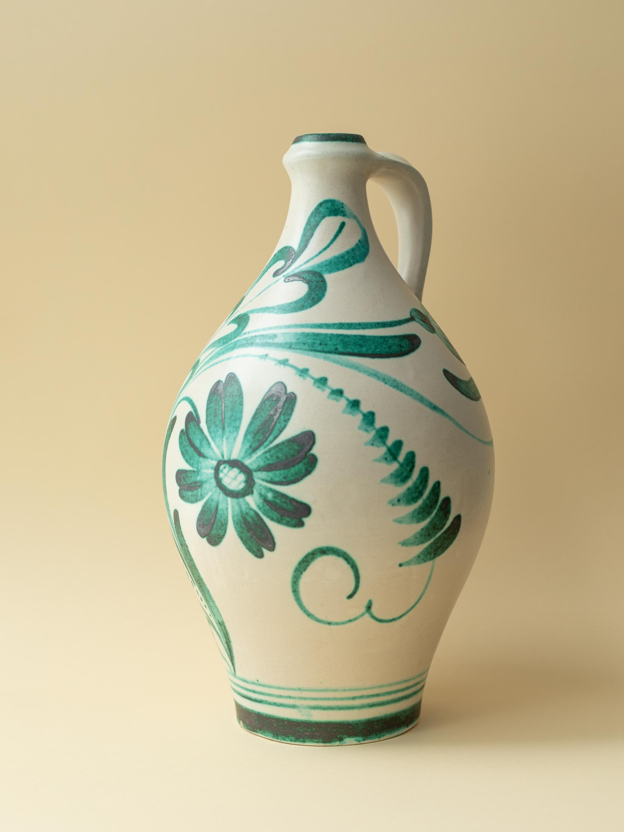 A crean coloured vintage ceramic vase by Kupittaan Savi with a handpainted floral motif in green. Scandinavian design from Finland. A closer up view from the front.