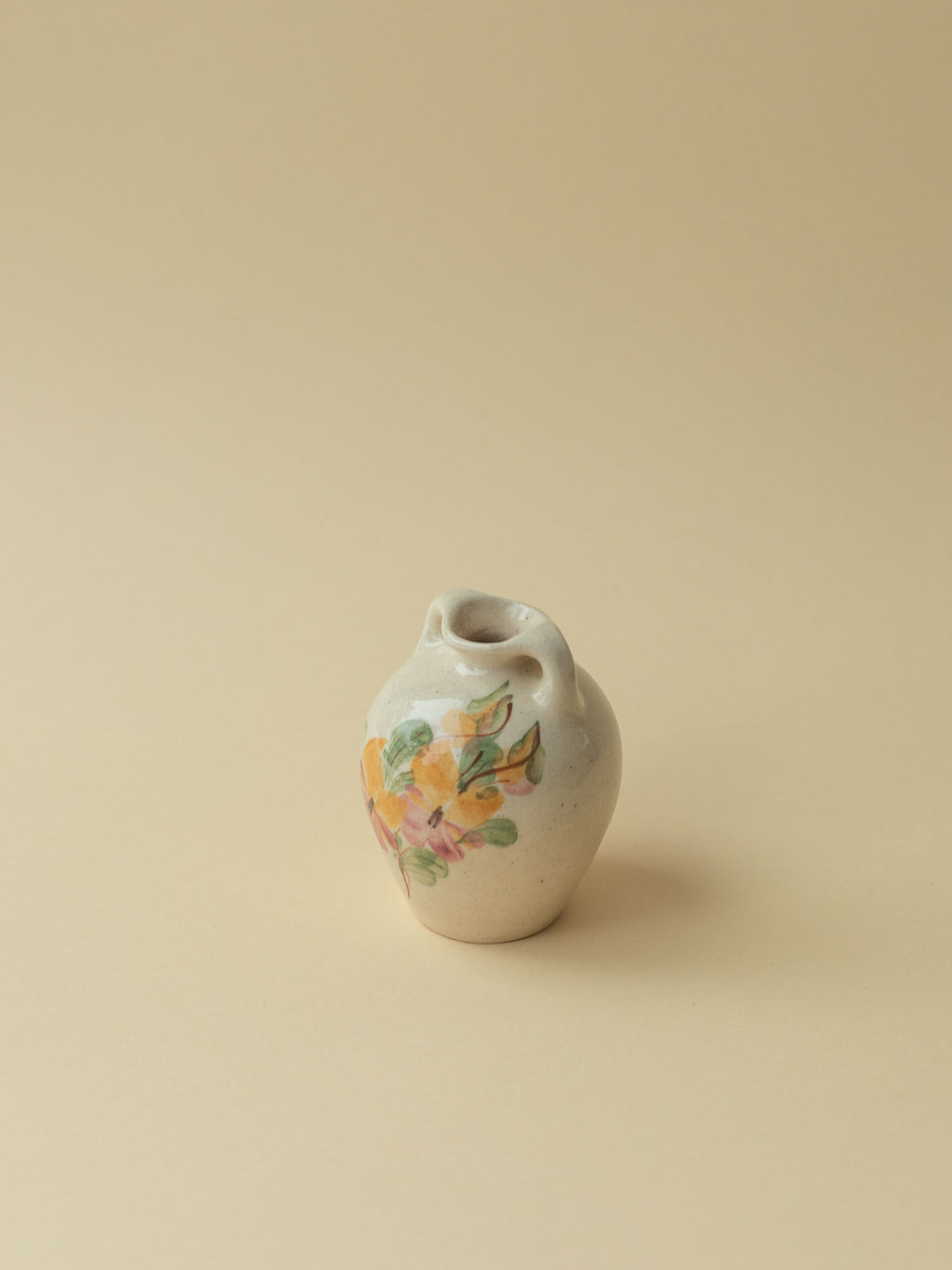 A miniature Kupittaan Savi vintage ceramic vase in amphora form.  Hand painted floral motif. A view from the backside. Scandinavian design from Finland.