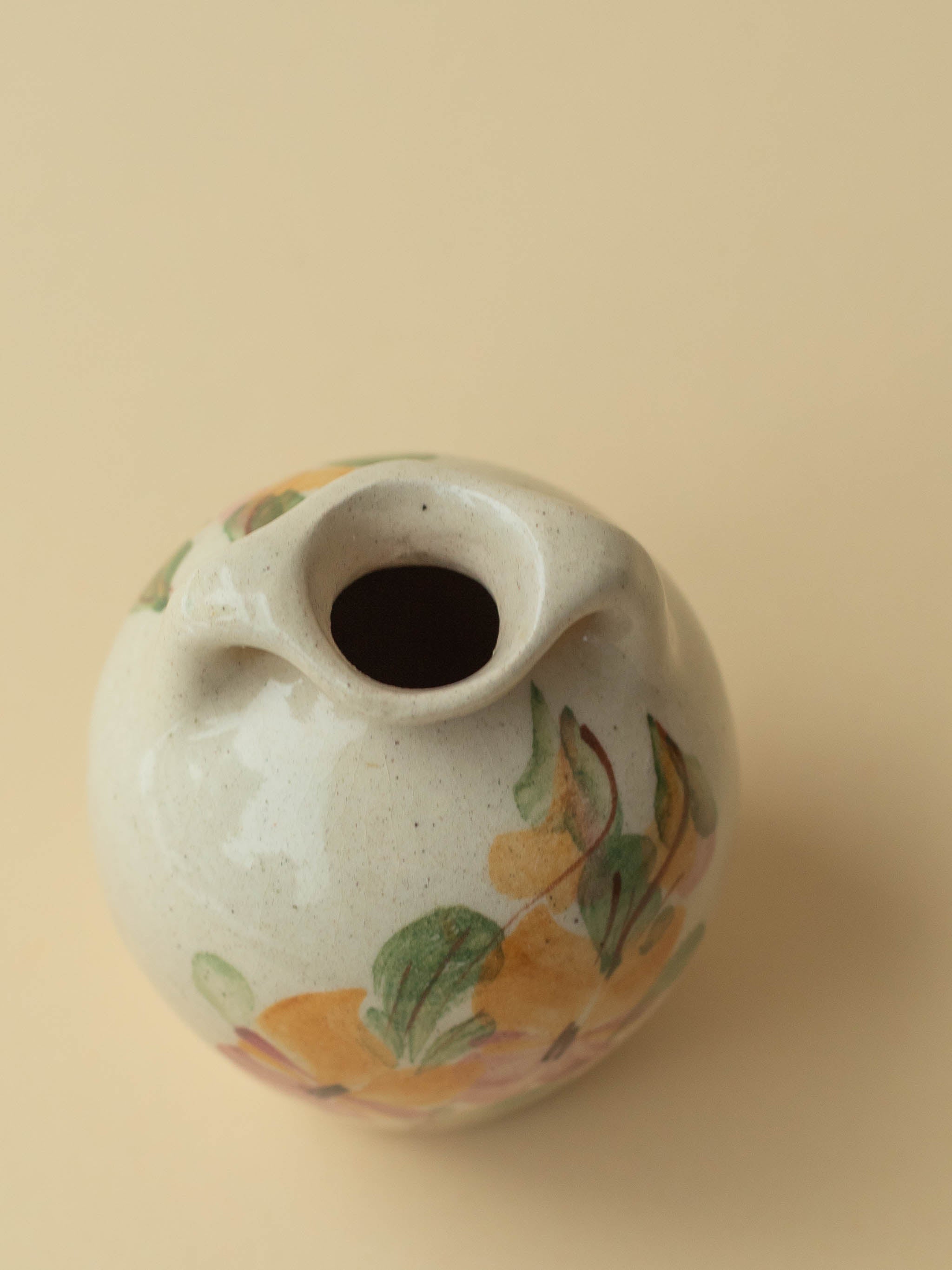 A miniature Kupittaan Savi vintage ceramic vase in amphora form.  Hand painted floral motif. A close up view from the above. Scandinavian design from Finland.