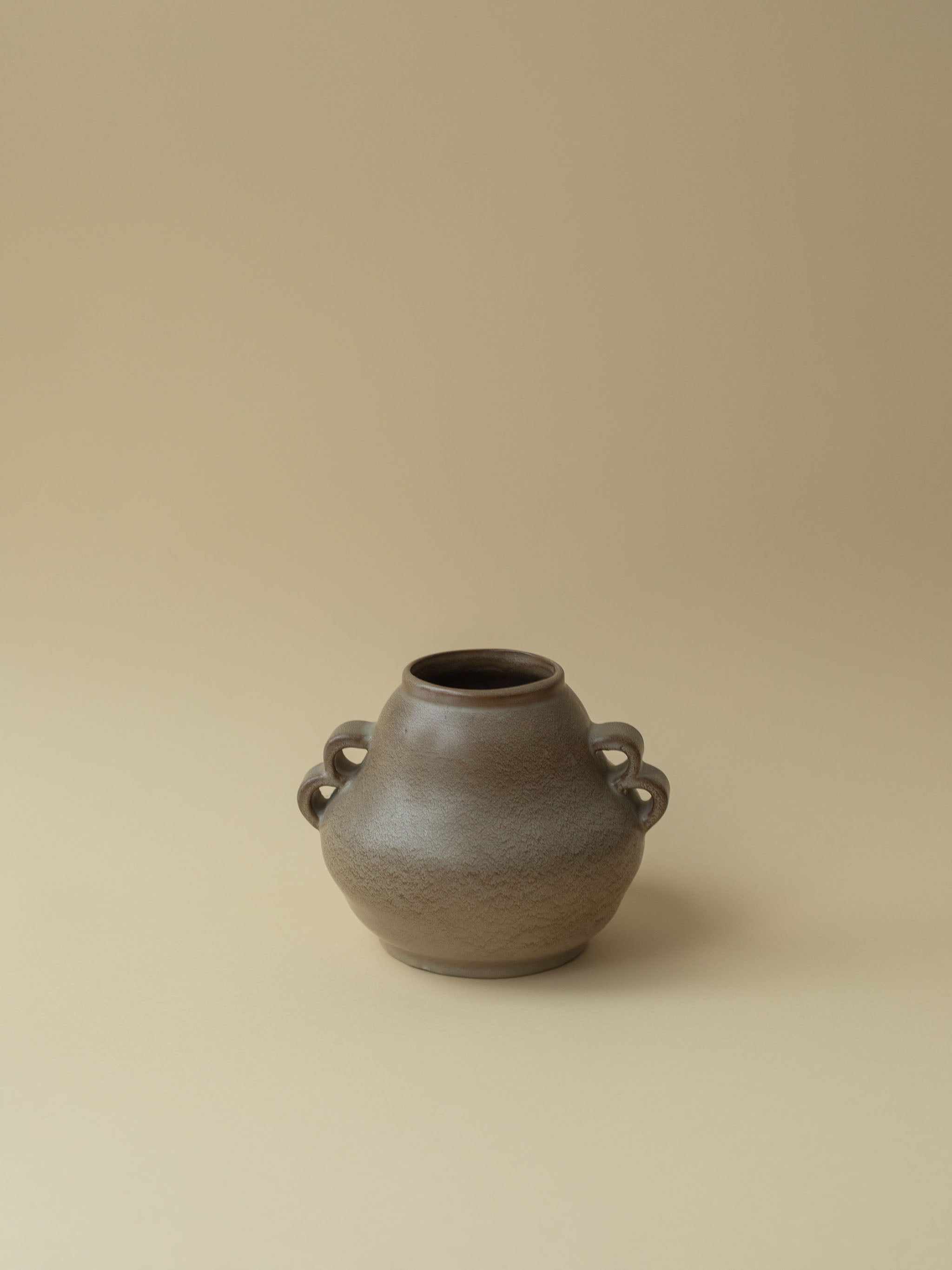 A brown vintage ceramic vase by Kupittaan Savi. Scandinavian design from Finland. A view from the front.
