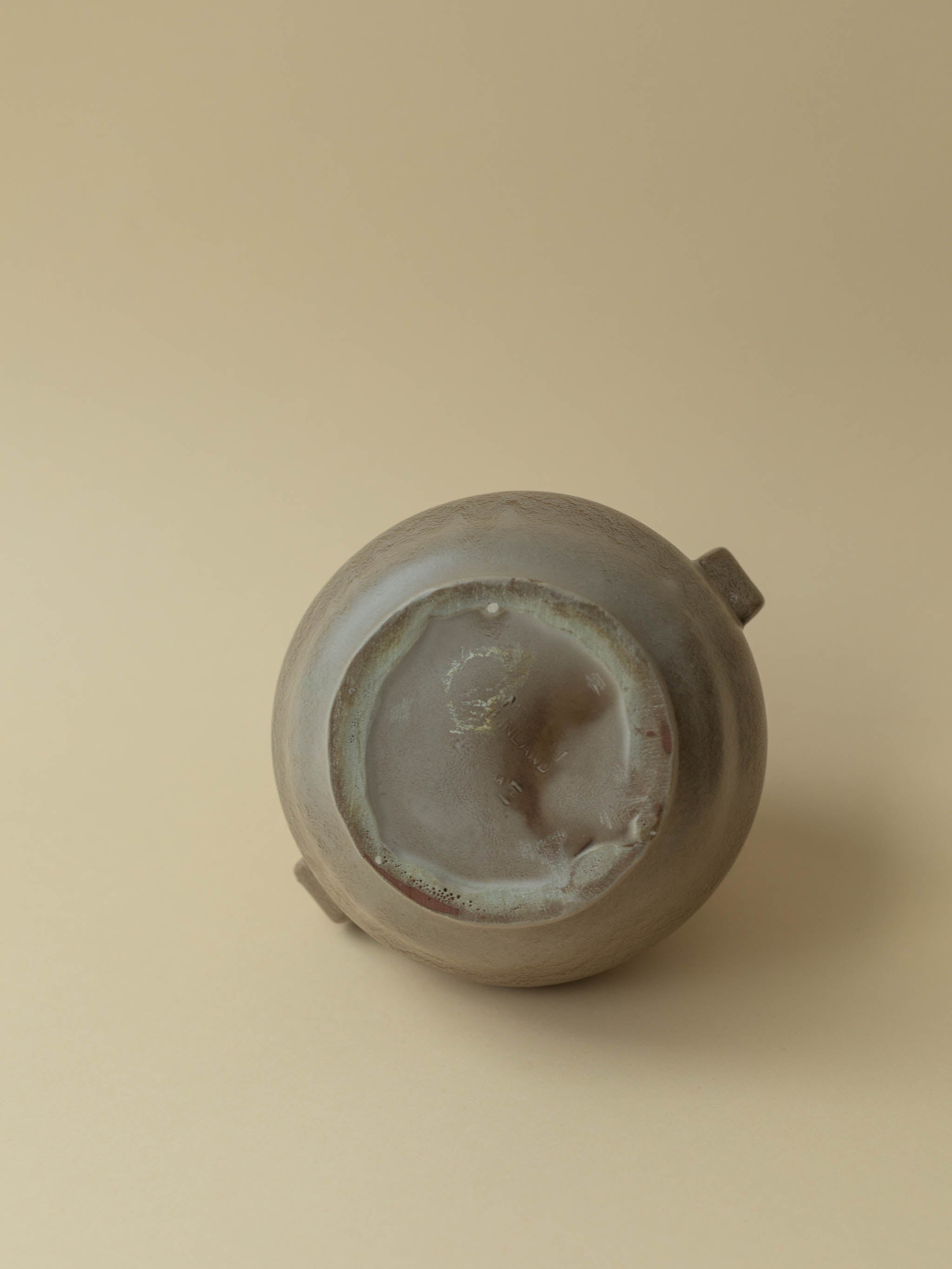 A brown vintage ceramic vase by Kupittaan Savi. Scandinavian design from Finland. A view of the bottom. Stamped Made in Finland.