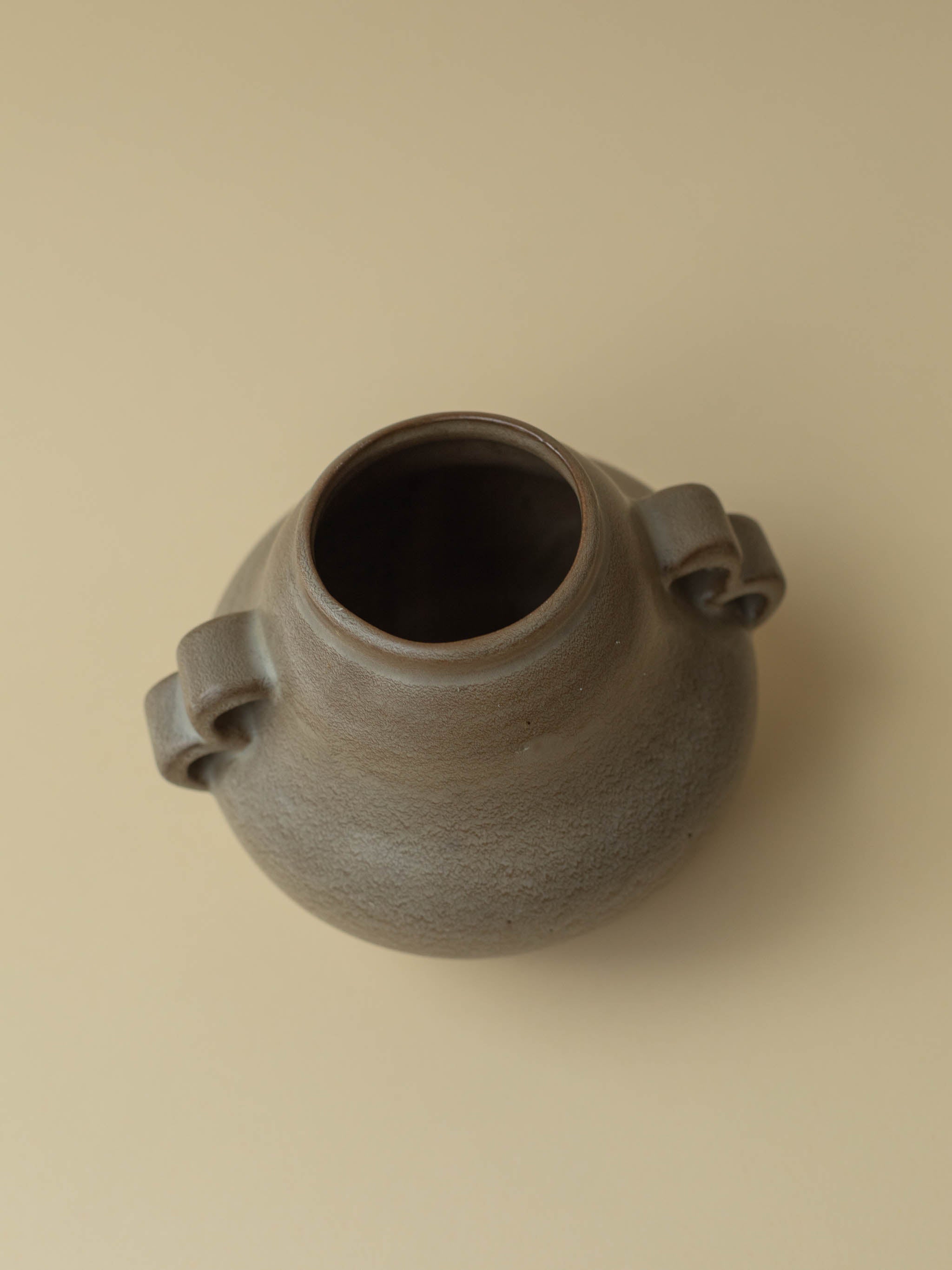 A brown vintage ceramic vase by Kupittaan Savi. Scandinavian design from Finland. A view from the top side angle.