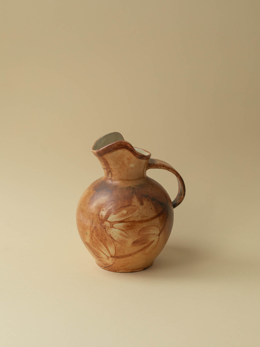 A brown toned vintage ceramic vase by Kupittaan Savi in jug or pitcher form. Signed at the bottom. Scandinavian design from Finland. A view from the side.