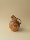 A brown toned vintage ceramic vase by Kupittaan Savi in jug or pitcher form. Signed at the bottom. Scandinavian design from Finland. A view from the side.