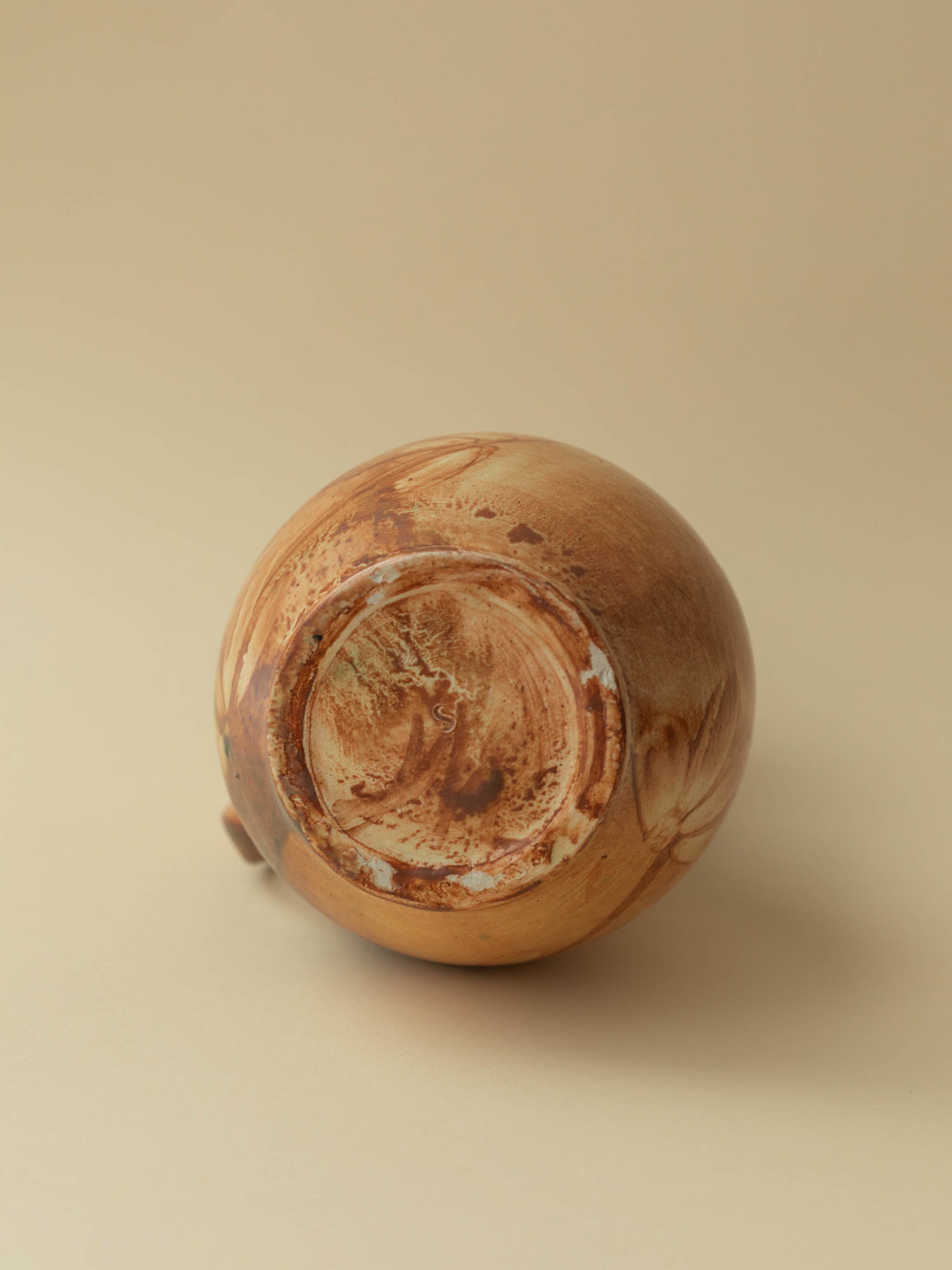 A brown toned vintage ceramic vase by Kupittaan Savi in jug or pitcher form. Signed at the bottom. Scandinavian design from Finland. A view of the bottom.