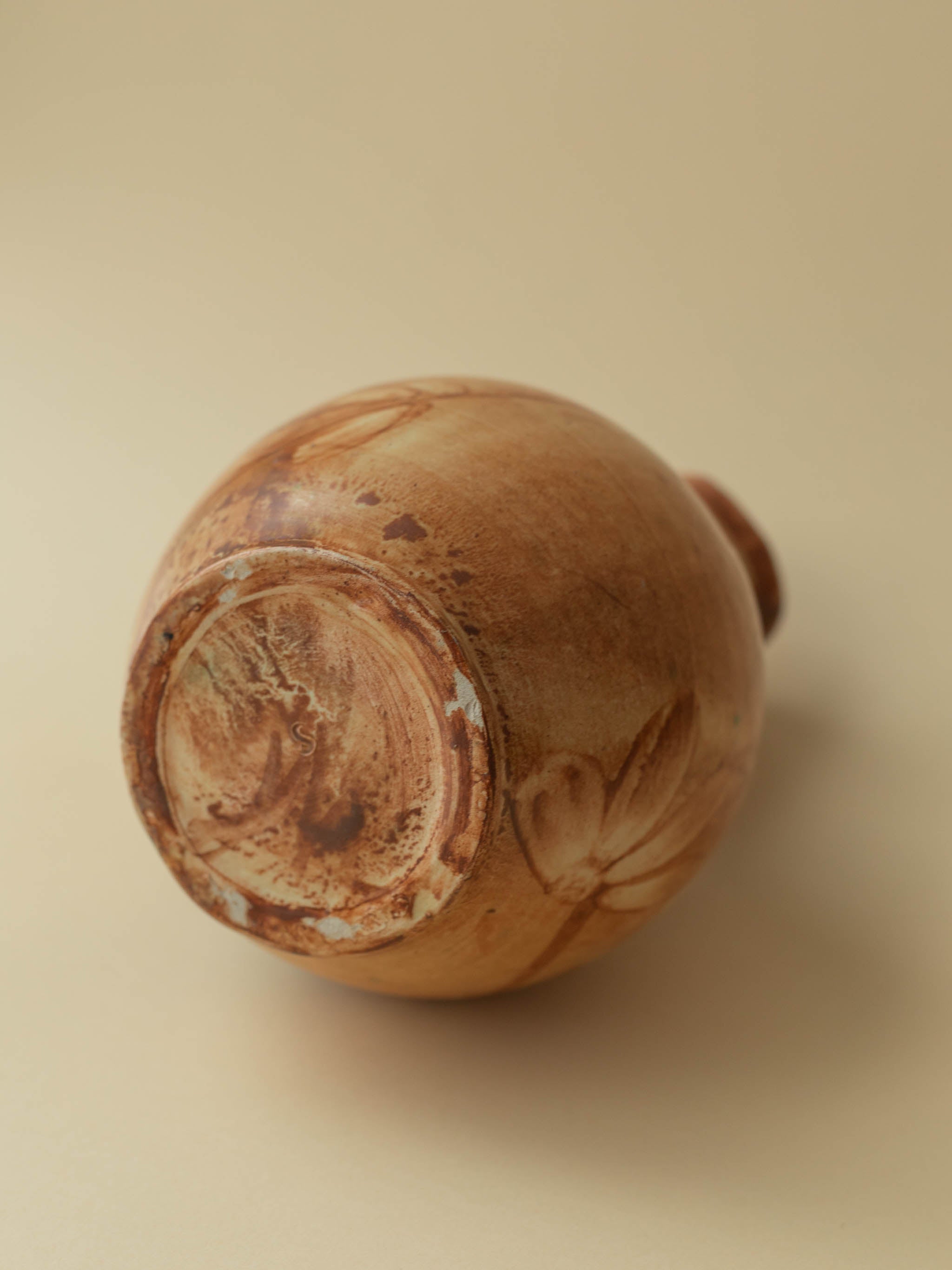 A brown toned vintage ceramic vase by Kupittaan Savi in jug or pitcher form. Signed at the bottom. Scandinavian design from Finland. A view from the back showing the bottom.
