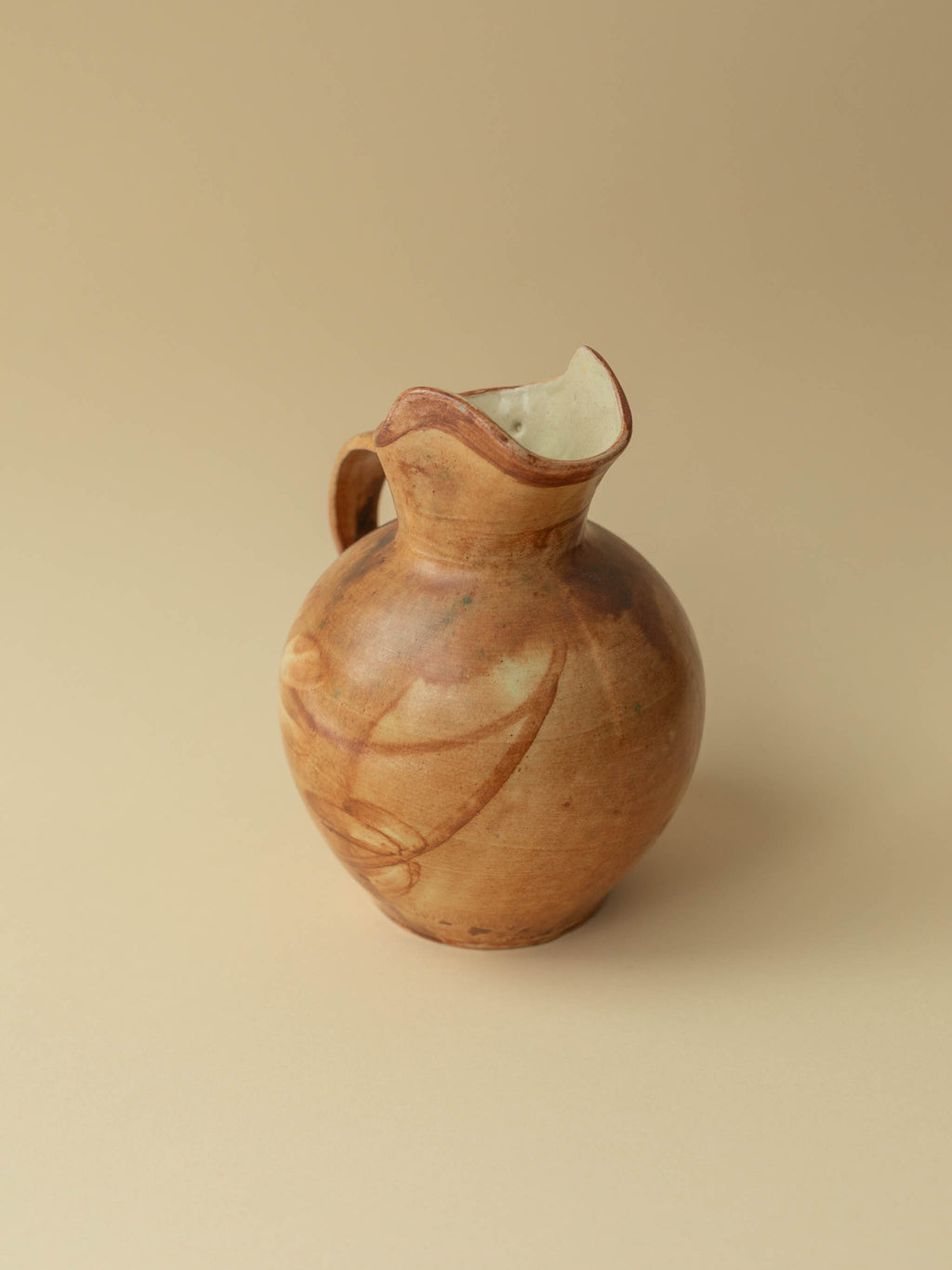 A brown toned vintage ceramic vase by Kupittaan Savi in jug or pitcher form.  Scandinavian design from Finland. A view from the front side.