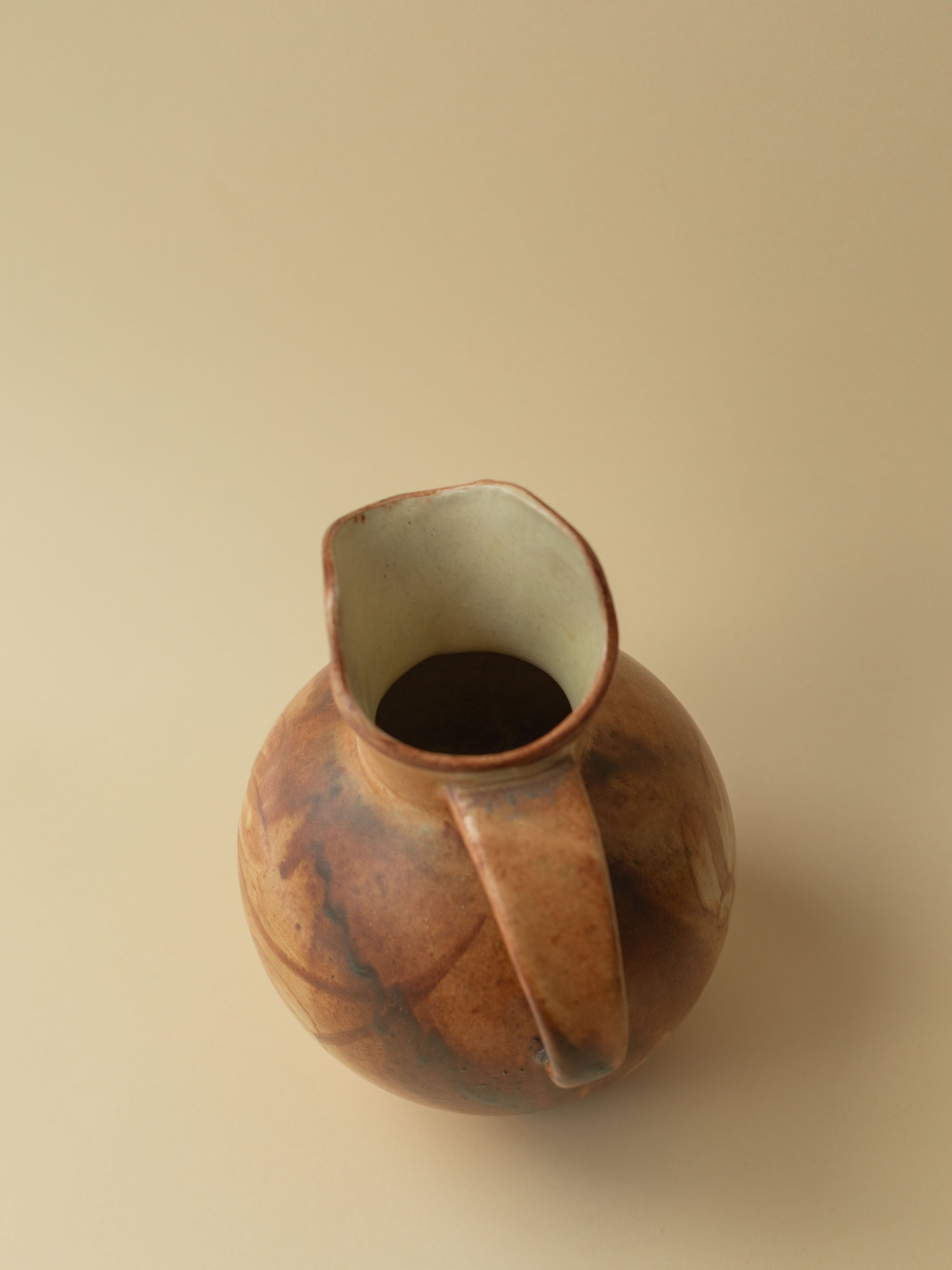 A brown toned vintage ceramic vase by Kupittaan Savi in jug or pitcher form. Scandinavian design from Finland. A view from above from back side.